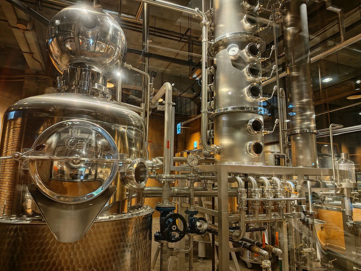 Stainless steel steam distillation columns and copper vessels inside a distillery