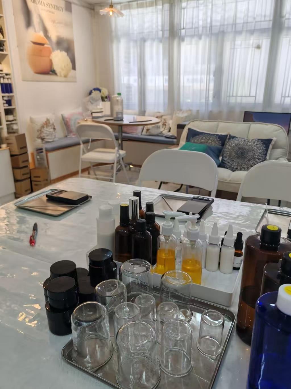 Natural skincare making workshop — glass jars, bottles, carrier oils and raw ingredients prepared in the studio